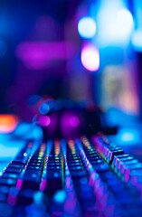 Colorful backlit gaming keyboard with neon lights in focused perspective © Parilov