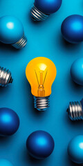 A vibrant yellow light bulb stands out among blue bulbs, symbolizing innovation and creativity.