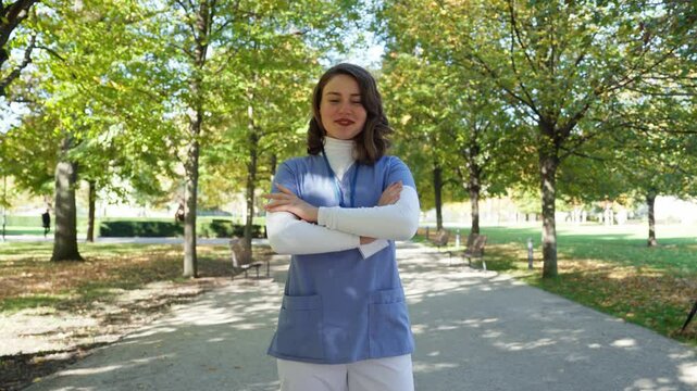 Video of beautiful nurse withhair in face, standing outdoors.