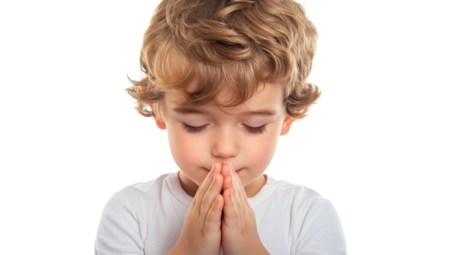 Child with curly hair practicing prayer with hands clasped in front of their face, calm expression in a softly lit environment