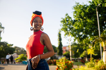 Garifuna woman wearing traditional orange turban in tropical park