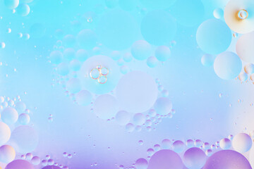 Beautiful cosmetic background. Soft purple blue abstract oil bubbles or face serum background. Cool macro photo