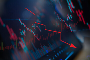 A stock market graph shows a downward trend. The downward trend is indicated by a red arrow pointing to the left