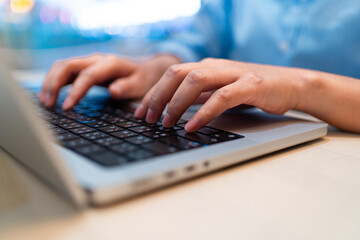A person is typing on a laptop computer. Concept of productivity and focus, as the person is engaged in a task that requires concentration. The laptop is open and positioned on a table