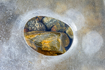 Unique rock formation revealed through a circular opening in the smooth stone surface at a natural site