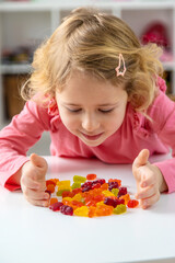 Child eating jelly candies at home. Selective focus.