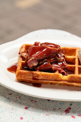 Portion of fresh waffle with beef brisket and cream cheese
