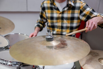 Drummer hitting cymbal with drumstick in music studio