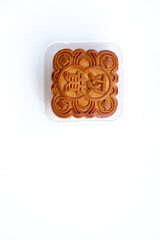 Mooncake in clear plastic container isolated on white. Bright lighting shows details and the '雙' (shuāng) character, meaning PAIR