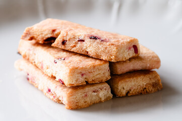 Stack of shortbread cookies with dry fruit in them on a white plate