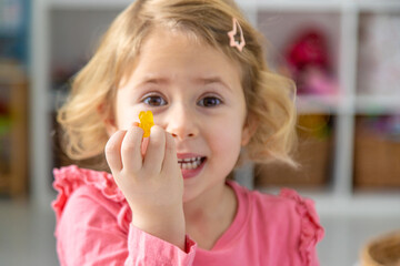 Child eating jelly candies at home. Selective focus.
