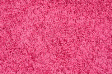 A close-up shot of a pink terry cloth fabric reveals its textured, looped surface, highlighting its soft and plush nature