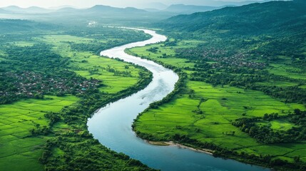 Aerial view of a winding river flowing through lush green fields and villages.