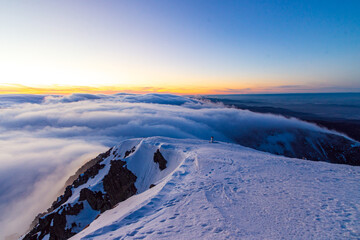 Zachód słońca w polskich górach Karkonosze na Śnieżka, po zmierzchu ponad chmurami. © krzys ser