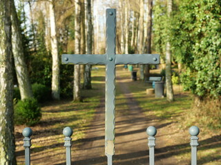 The cemetery gate with a metal cross symbolizes mourning, remembrance, and peace. A silent place of reflection, marked by dignity, spirituality, and eternity.