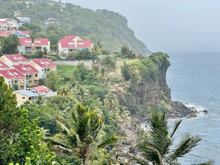 landscape of guadeloupe in the french west indies with view of houses on a cliff by the sea with...