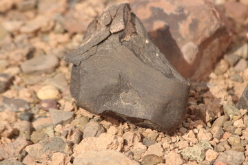 A close-up view of a black stone on the ground