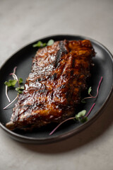 Grilled ribs with radish and microgreen on a plate