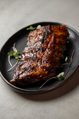Grilled ribs with radish and microgreen on a plate