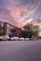 Fototapeta premium Wide angle of a street with parked cars, sunset sky.