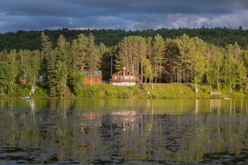 Fototapeta premium View on a cottage by the lake under the sun