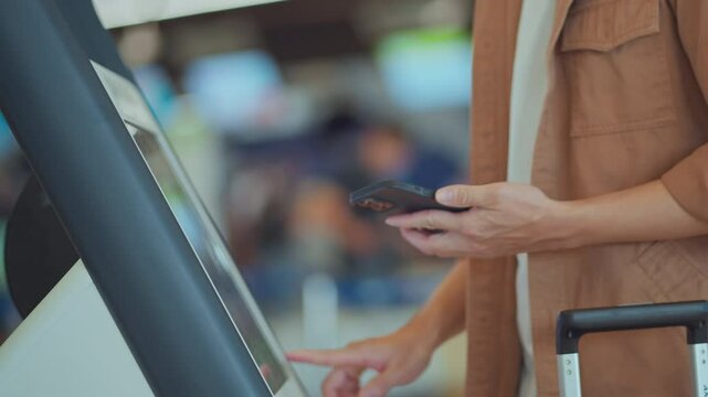 Closeup hands of asian man using self check-in machine at the airport terminal getting the boarding pass, Technology in airport, Tourist journey trip concept