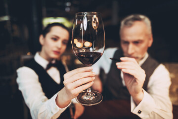 Sommelier is studying sediments in glass of wine.Waiter holds glass of red wine. Wine tasting.