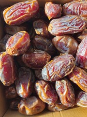 Dates in a bowl on a wooden background. Dried fruits. Dried date fruit. PNG, Ramadan. Organic dried medium fruit snack. Dried date palm.