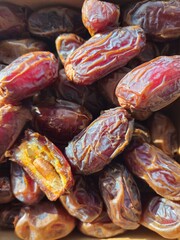 Dates in a bowl on a wooden background. Dried fruits. Dried date fruit. PNG, Ramadan. Organic dried medium fruit snack. Dried date palm.