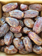 Dates in a bowl on a wooden background. Dried fruits. Dried date fruit. PNG, Ramadan. Organic dried medium fruit snack. Dried date palm.