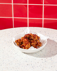 Portion of crispy fried boneless chicken thighs with red sauce