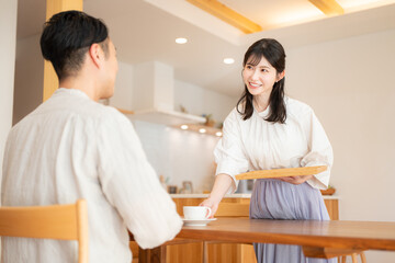 Obraz premium 夫にコーヒーを出す妻