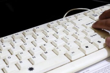Close-up of Worn White Computer Keyboard with User's Hands