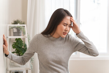 Young Asian females feeling dizzy after standing too fast, have symptoms of low blood pressure