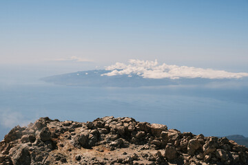 Stunning aerial view of a volcanic landscape overlooking a serene ocean and distant islands under a clear blue sky. Perfect for travel, nature, and geography projects.