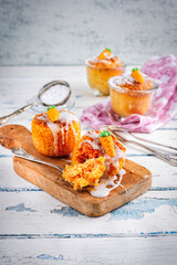 Traditional artisan carrot cake baked in glass jar with nuts and sugar frosting topping served as close-up on a wooden board
