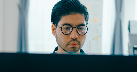 Closeup young adult Asia male freelance eyeglasses typing write prompt AI bot IT app program nomad, video game, terminal with coding, user interface, designer, big data center on desktop computer.