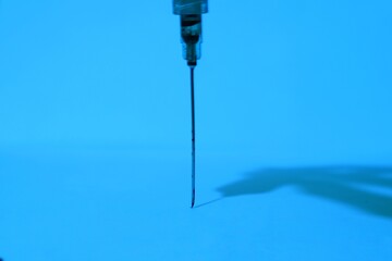 Close-up of a Needle's Precise Point Against a Vibrant Blue Background