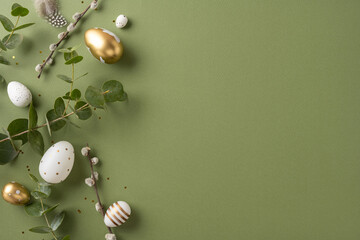 Decorative Easter eggs in various designs scattered on a surface with green leaves