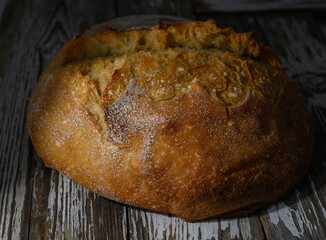 Freshly baked artisan bread resting on rustic wooden surface in warm golden light