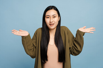 Young woman shrugging shoulders expressing uncertainty and confusion
