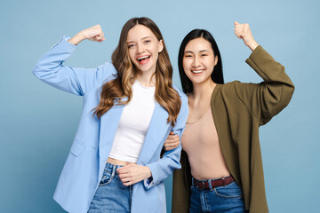 Two happy businesswomen showing strength and celebrating success