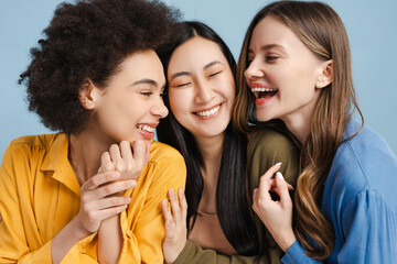 Fototapeta premium Three happy young women sharing a moment of laughter and joy