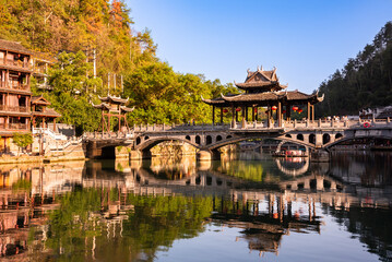Fototapeta premium Old bridge in Fenghuang ancient town, China. Traditional chinese wooden houses in old watertown