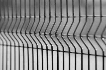 metal fence made of 3d mesh panels close-up on a gray background