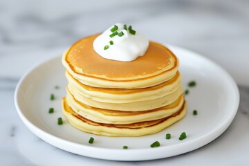 Delicious cottage cheese pancakes with herbs served on a plate, topped with sour cream. Concept highlights local farm products and innovative culinary creations.