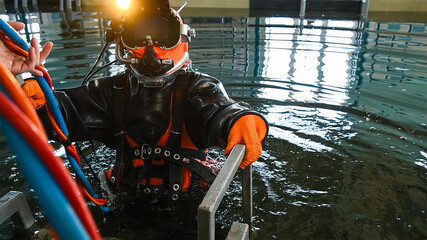 Professional diver in a diving suit, helmet and gear, ready to dive for underwater work