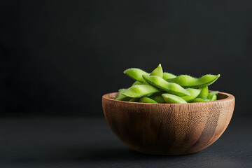 Fresh green edamame in dark wooden bowl, showcasing vibrant colors and textures. This healthy snack is perfect for any occasion