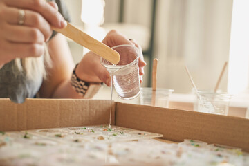 Hands creating resin art: female, caucasian, adult crafting with epoxy resin and molds.