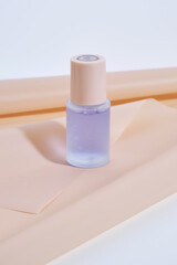 A bottle of blue serum on a delicate beige background.